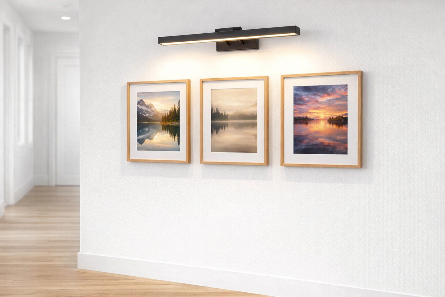 led picture light above framed photographs in hallway gallery wall