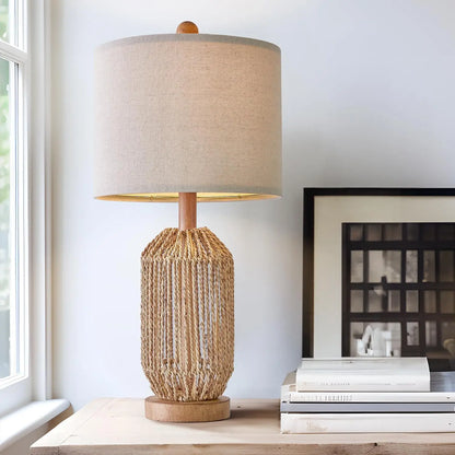 small rattan lamp with linen shade on modern console with stacked books