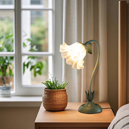Pink flower lamp on nightstand casting cozy warm light in a bedroom