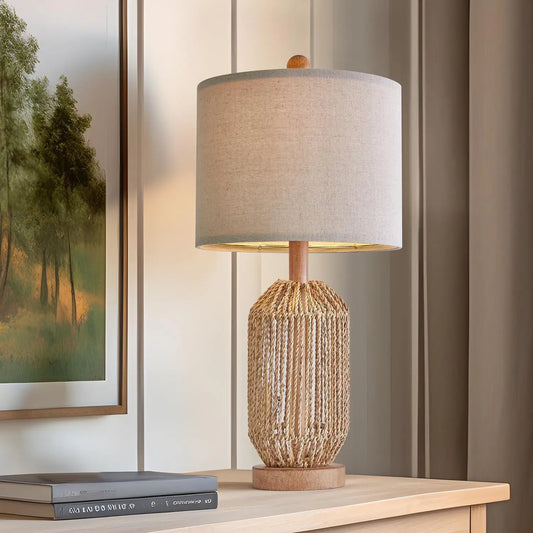 rattan table lamp with woven body and linen shade on wood console