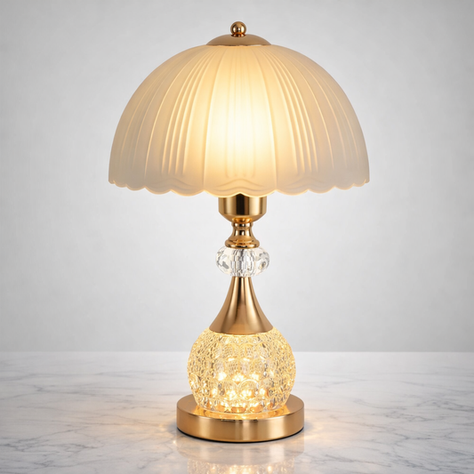 crystal table lamp with frosted petal shade and illuminated crystal base on elegant marble surface