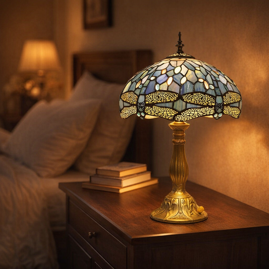 dragonfly stained glass lamp glowing on dark wood nightstand in cozy bedroom