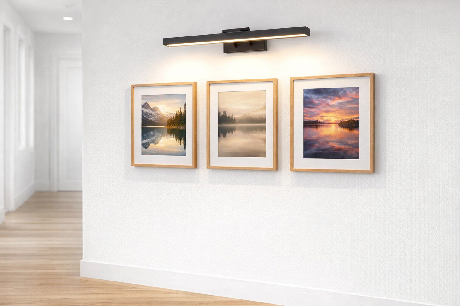 led picture light above framed photographs in hallway gallery wall