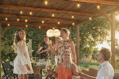 outdoor string lights with bulbs hanging over garden pergola gathering